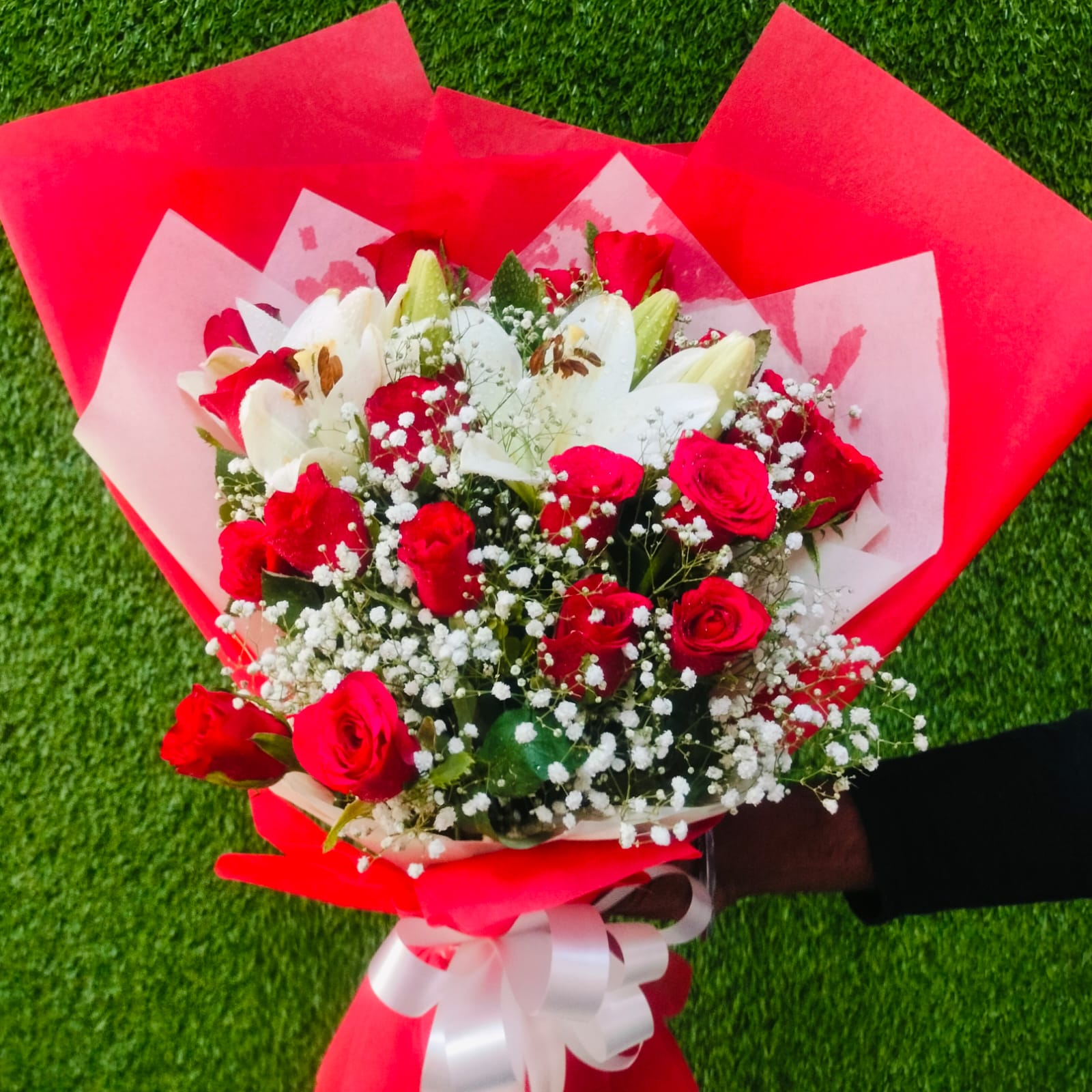 Red and white rose bouquet wrapped in red paper – FlowerDekho