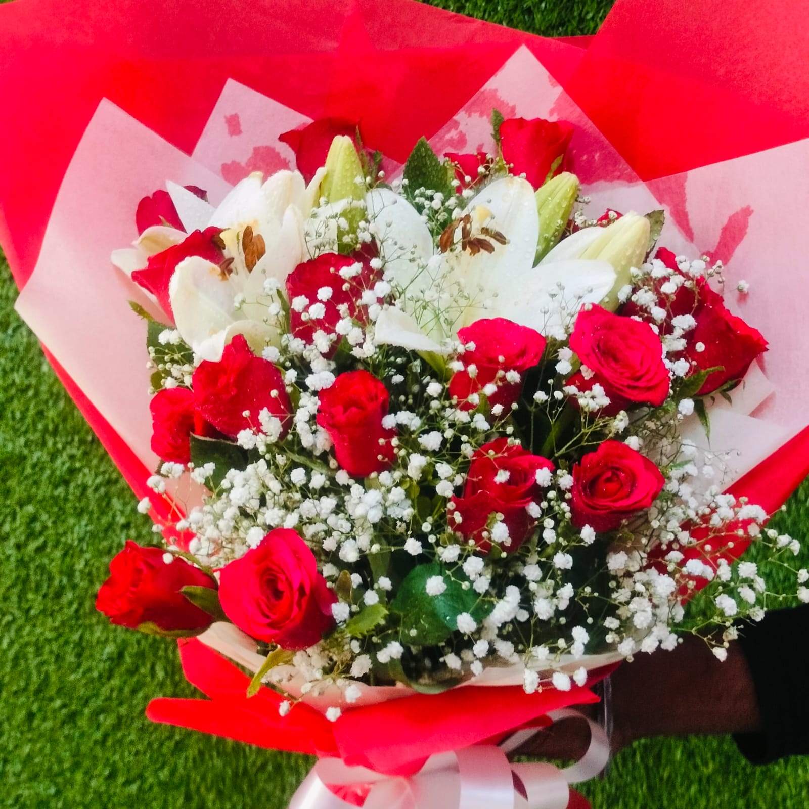 Red and white rose bouquet wrapped in red paper – FlowerDekho